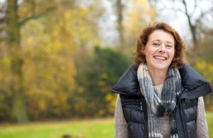 Smiling middle aged caucasian woman illustrating the concept of being afraid of the dentist no longer