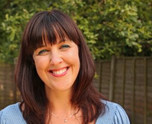 Outdoor headshot of a smiling middle aged caucasian woman